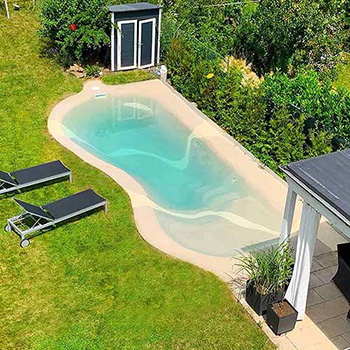 Ein Beachpool in einem Garten mit vielen Pflanzen, einer Hütte, einem Schrank und Sitzmöglichkeiten